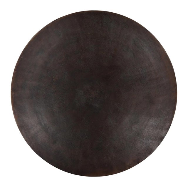Round top coffee table with a distinctive scalloped base, creating a monolithic silhouette with subtle architectural...