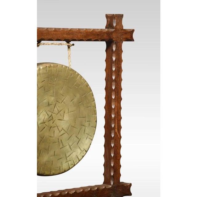Oak table gong of square form having carved moulded frame supporting the original gong inscribed Burmese. Dimensions...