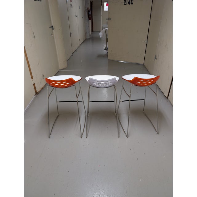 Set of three bar stools of technopolymer shell with high gloss white seat - 2 with transparent orange back and one with...
