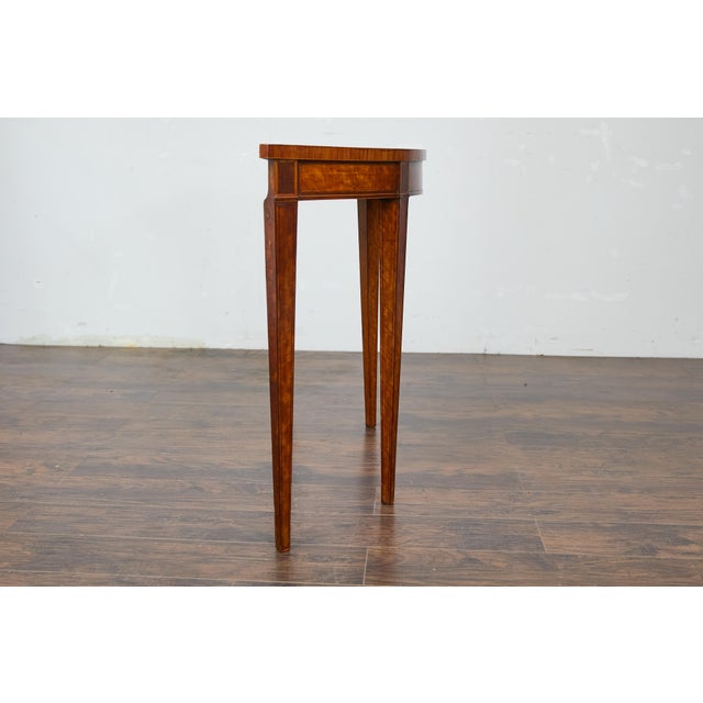 An English Neoclassical walnut demi-lune console table from the 19th century with tapered legs. This English Neoclassical...