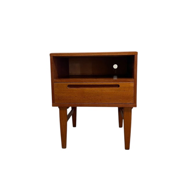 This mid-century modern nightstand features a clean, functional Danish design executed in warm teak veneer and solid wood...