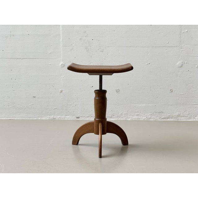 Classic piano stool made of solid wood with a functional spindle mechanism for stepless height adjustment. The slightly...