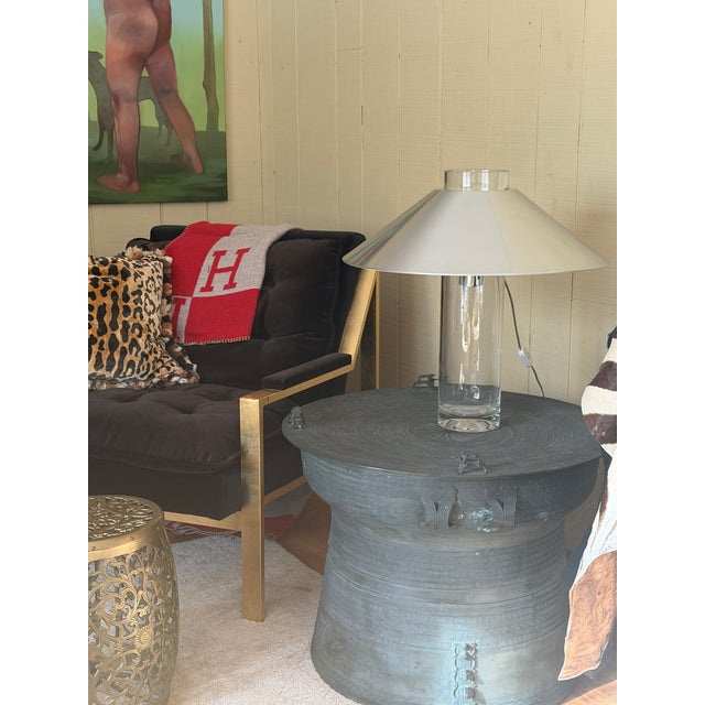 A very tall glass cylinder with a big metal ‘hat’ that floats over the glass top. A smart and simple design.