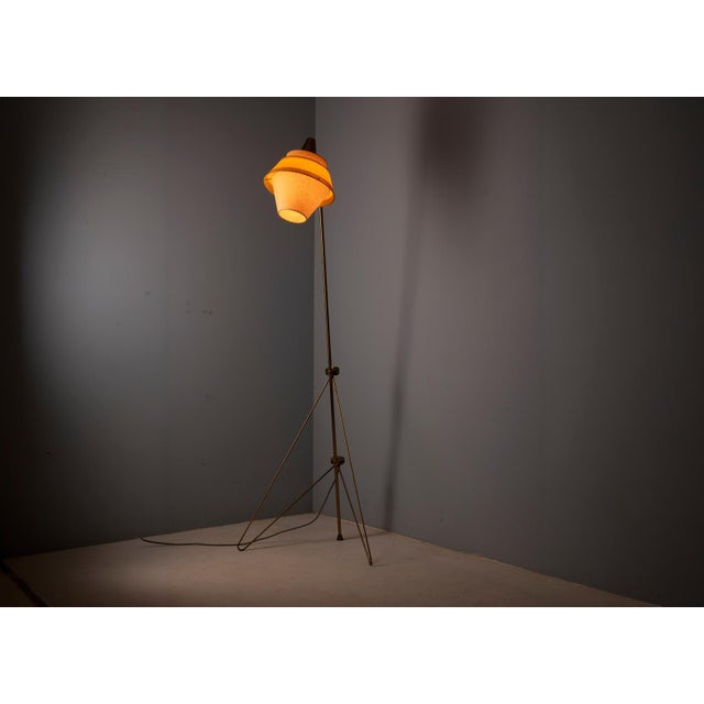 A distinctive vintage floor lamp designed by josef hůrka for napako, featuring a slender metal frame, an elevated conical...