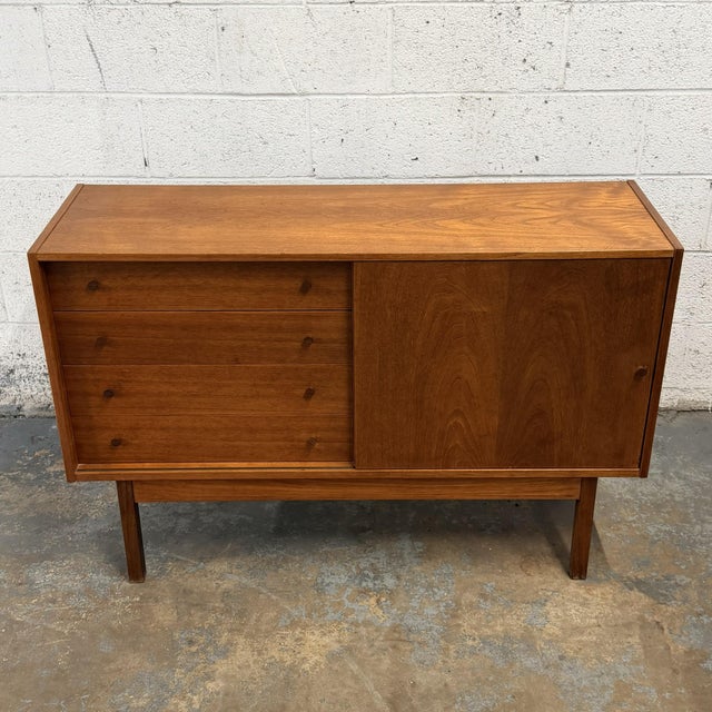 This Danish teak low sideboard has a smart, understated design with a very useful mix of storage. One side is fitted with...