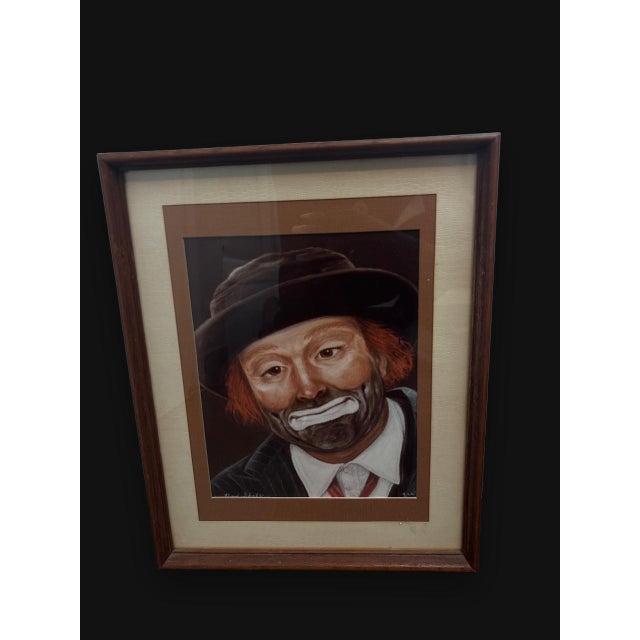 The vintage framed print painting by artist Jon Helland is a unique and collectible piece featuring a portrait of a clown...