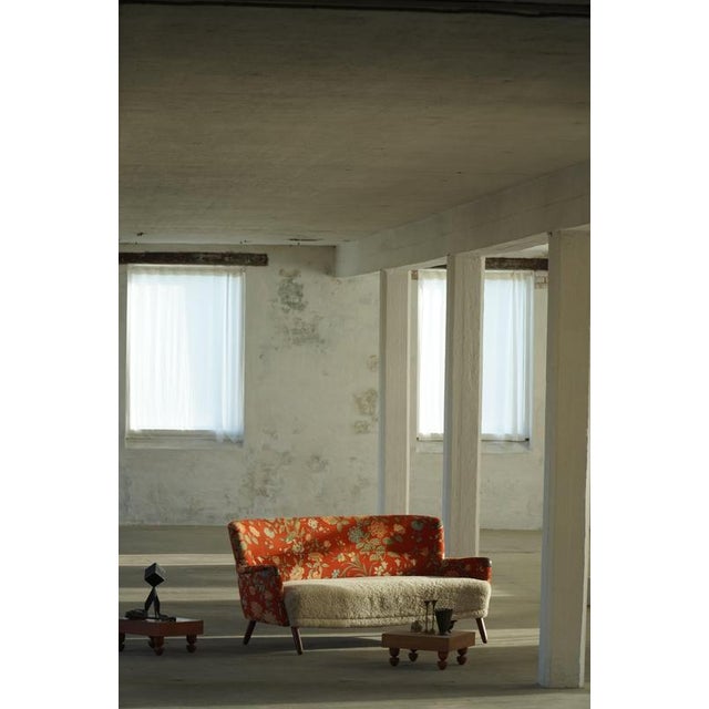 A beautiful and characterful Danish three-seater sofa from the 1960s, featuring an elegant curved silhouette and warm...