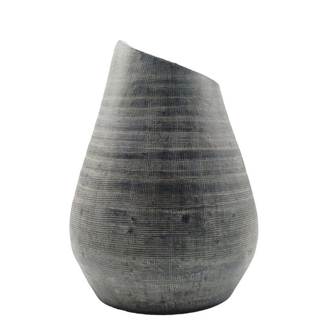 A cylindrical ceramic vase with retro-style lines in anthracite grey, featuring an aged, matt finish and a distinctive,...
