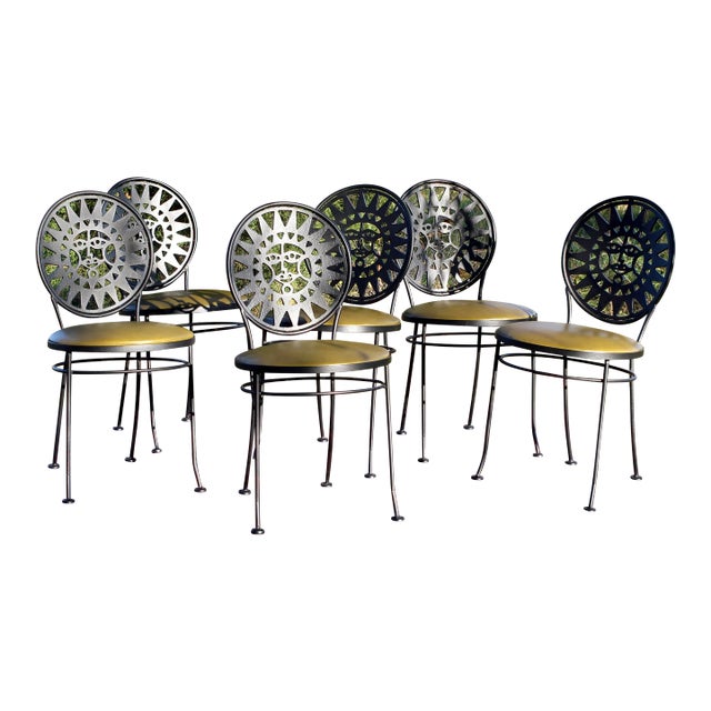 Sold in pairs and 6 chairs available. Midcentury wrought iron Arthur Umanoff "Mayan sun" chairs with a sun face design on...