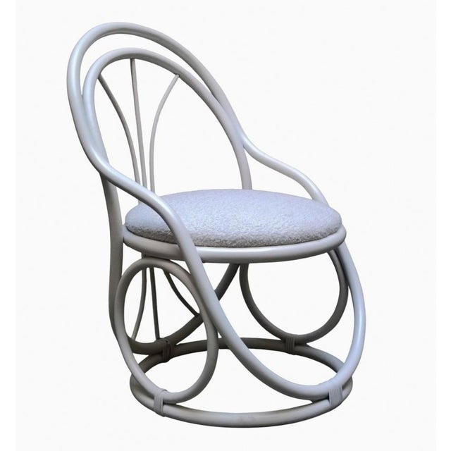 White curved wood armchair. It has a distinctive design with a curved wood frame, characterized by rounded shapes and a...