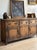 An antique country dresser base with three frieze drawers above three raised-panel cupboard doors, the drawers fitted with...