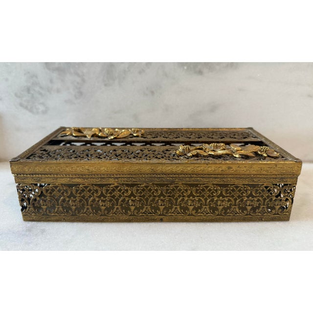 Vintage mid century Hollywood Regency gold toned brass tissue box with hinged lid featuring intricate floral and bird...