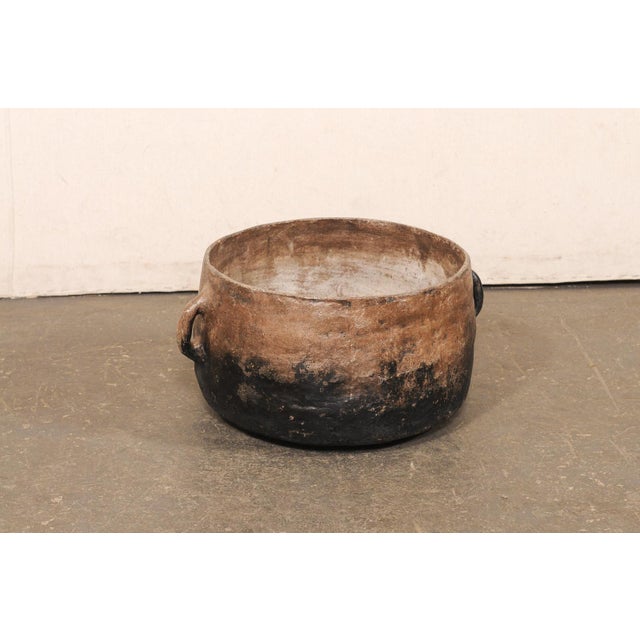 A Guatemalan large earthenware cooking vessel from the early 20th century. This antique pot from Guatemala has a hand-...