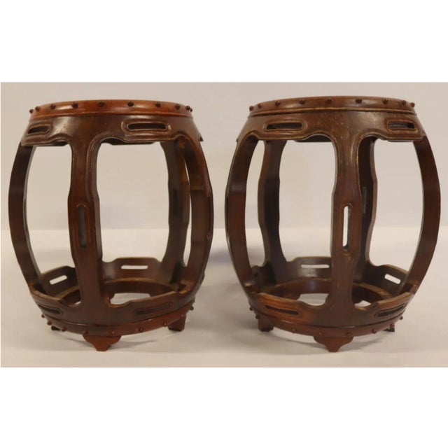 A stylish pair of Chinese hardwood barrel-shaped stools with circular inset tops, studded top and base border, pierced...