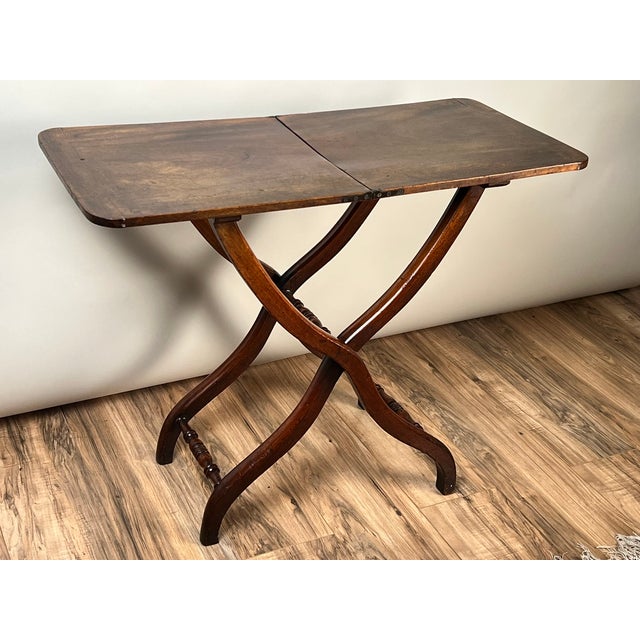 Elegant in its simplicity and ingenious in its construction, this English Regency folding table dates to approximately...