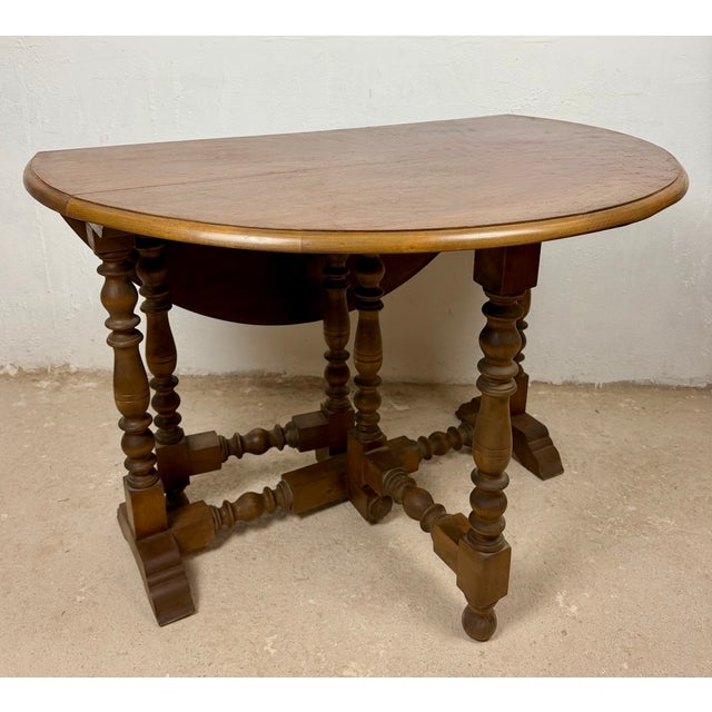 Spanish drop-leaf table dating from the mid-20th century. Crafted in wood, it features two folding leaves that transform...