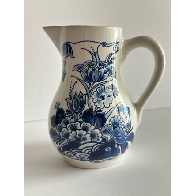 Royal Delft hand painted small pitcher. Blue and white with floral pattern. Approximately 4 1/2” x 5 1/2”.