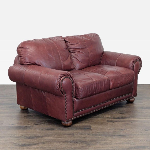 This comfortable leather loveseat features rolled arms and decorative stud accents for a classic look. The deep cushions...