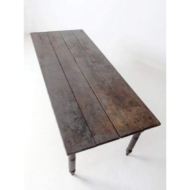 This early farmhouse table features a simple, honest design with a beautifully aged patina. The rectangular plank top...