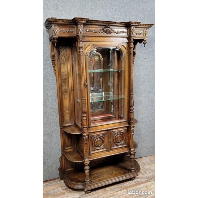 Renaissance-style carved oak bookcase, circa 1850 Three doors at the front, one fully glazed Mirror back Rounded sides...