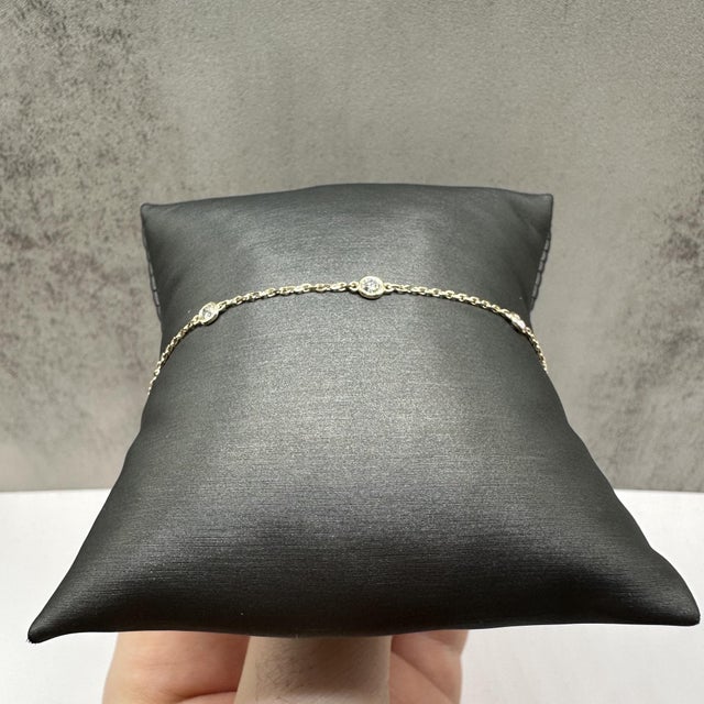 This elegant diamond station bracelet in 14kt yellow gold features 0.33 carats total weight of natural GH SI2–I1 round...