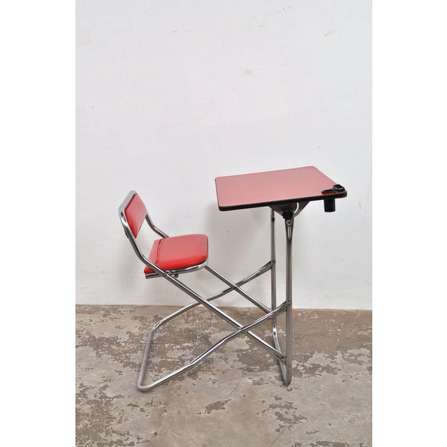 Folding school desk with chrome tubular frame, Formica top, skai leather seat and black plastic pen tray. This beautiful...