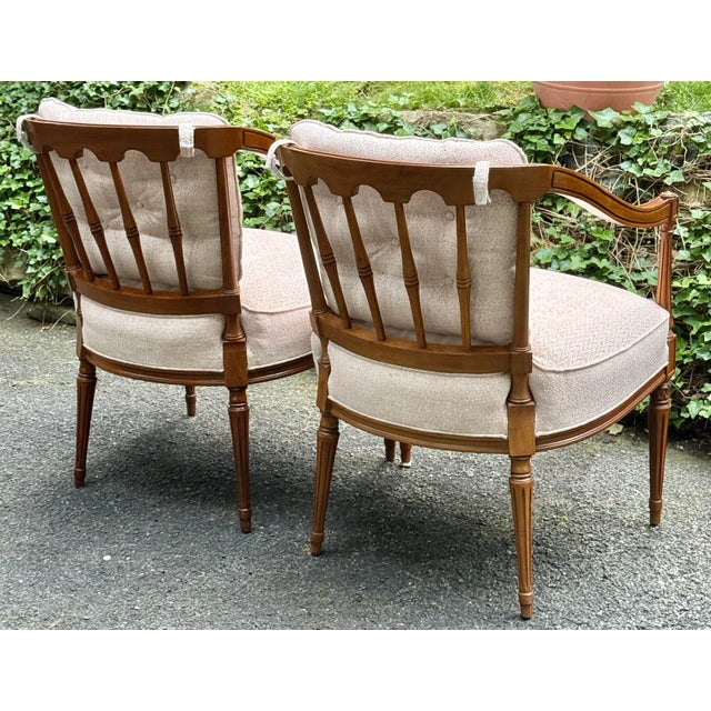 Beautiful pair of Louis XVI armchairs with elegant fluted legs with carved detail, upholstered back and seat cushions,...