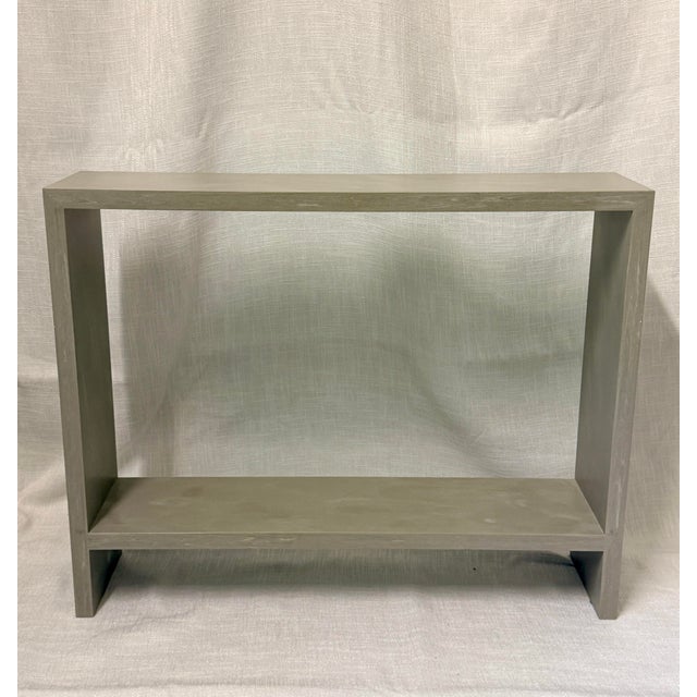 A sculptural skinny console table crafted from micro-polished cement, defined by clean architectural lines and a refined...