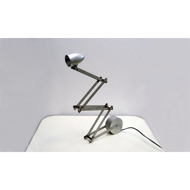 This is an adjustable halogen table lamp from circa the 1980s and produced in France. It features an adjustable aluminum...