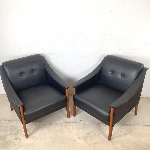 An elegant pair of Italian Modern lounge chairs defined by graceful sculptural lines and understated sophistication....