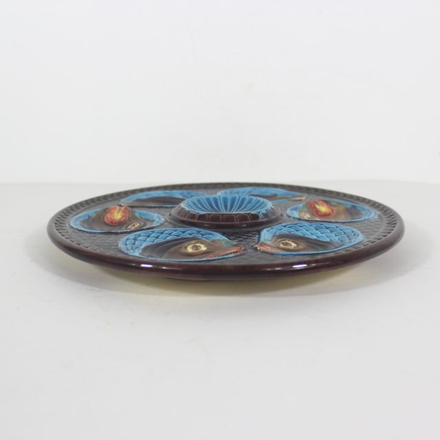 A Barbotine majolica oyster plate from La Faïencerie d’Onnaing in northern France, circa 1870. Six fish heads surround a...
