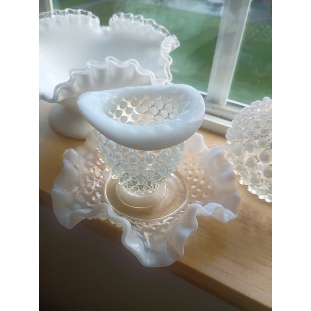 ​A stunning four-piece collection of vintage Fenton Art Glass, featuring the highly sought-after Hobnail pattern in...