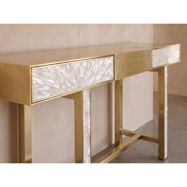 The Arcana Console Table is a sculptural statement piece that brings together the luminous beauty of natural mother-of-...