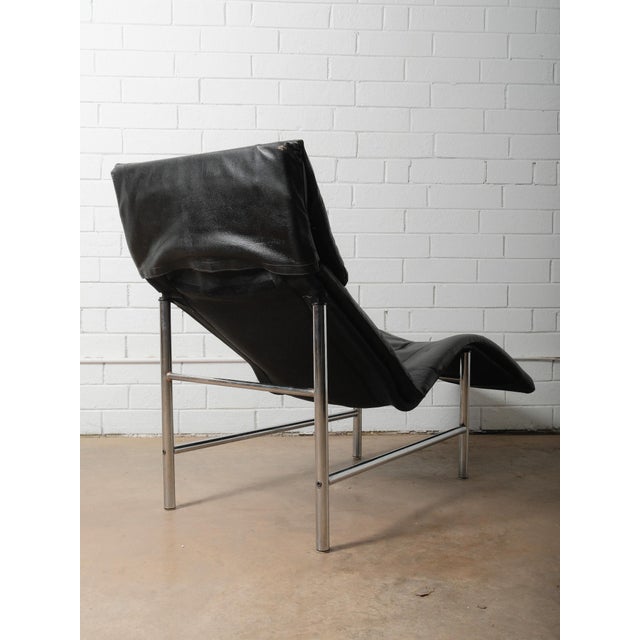 A vintage 1980s Tord Björklund leather and chrome lounger for IKEA, featuring the designer’s signature sculptural, wave-...
