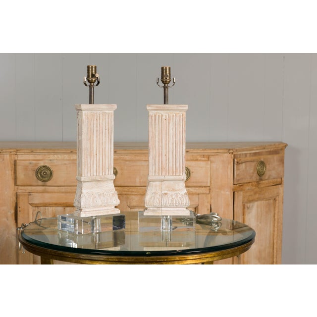 A pair of Italian Midcentury carved pine pilaster table lamps on lucite bases, US wired. Introducing a striking pair of...