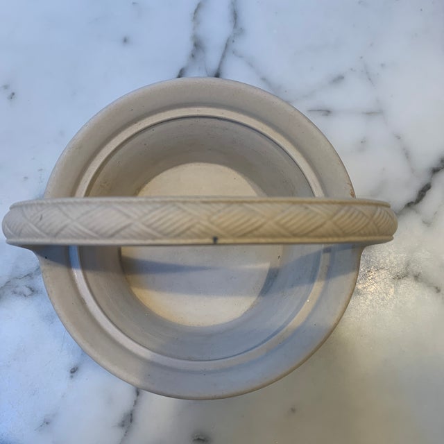 This charming small bisque basket has very fine detailing representing wicker around the side and braiding on the handle....