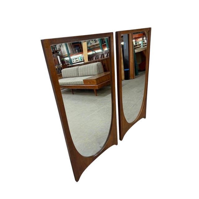 Elevate your space with this striking pair of Mid-Century Modern Broyhill Brasilia walnut wall mirrors. Showcasing the...