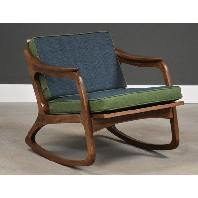 A mid century modern solid beech walnut color rocking chair with a woven cane back designed by Lawrence Peabody....