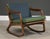 A mid century modern solid beech walnut color rocking chair with a woven cane back designed by Lawrence Peabody....