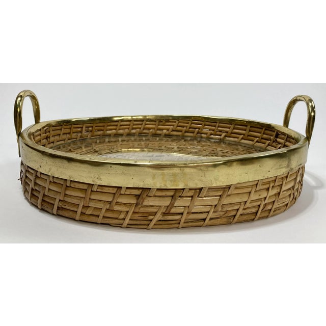 Vintage Gabriella Crespi style coiled rattan and brass tray. Features thick brass rim and handles with inset glass. A...