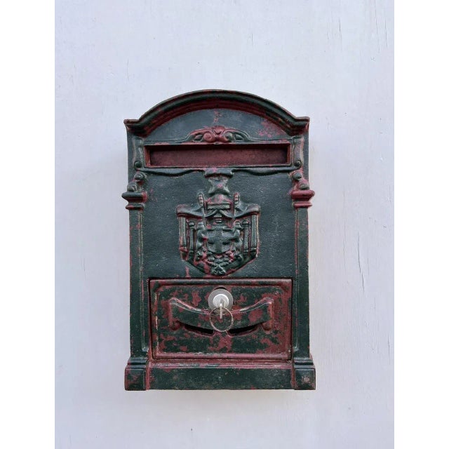 Late 19th century French cast iron facade letterbox with decorative relief of a coat of arms and leaves, originating from...
