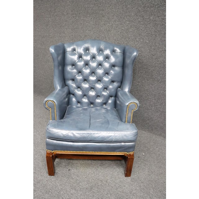 Leathercraft wingback chair in blue tufted leather with brass nailhead trim and mahogany frame.