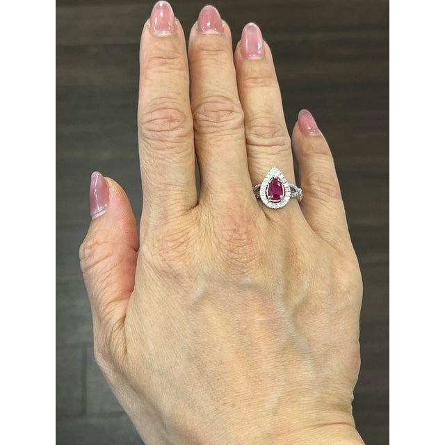 This beautiful natural ruby and diamond ring has a pear shaped ruby weighing 1.06 ct, with surrounding diamonds weighing...