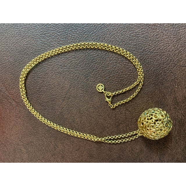 This striking Givenchy gold-tone chain necklace features a bold round disk ball pendant with a clean, modern Mod...