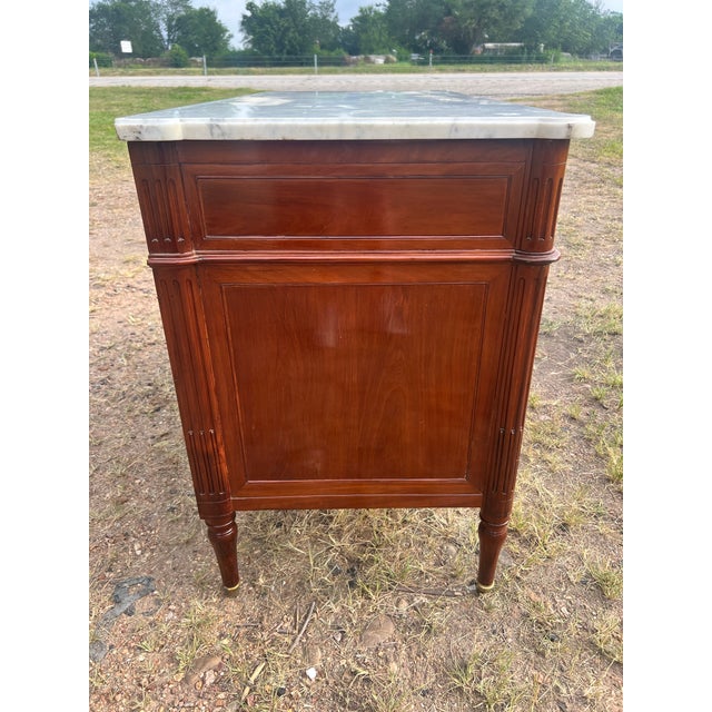 A refined 19th-century French Louis XVI commode, expertly crafted in richly figured walnut with beautiful bookmatched...