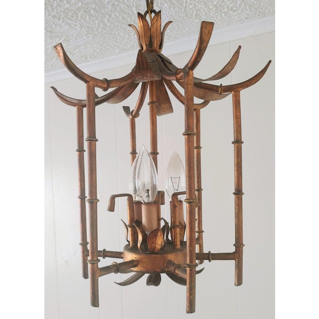 Here's a faux bamboo in brass light fixture pagoda style from the 1950s-60s. Great designer piece.. Wiring with chain is...