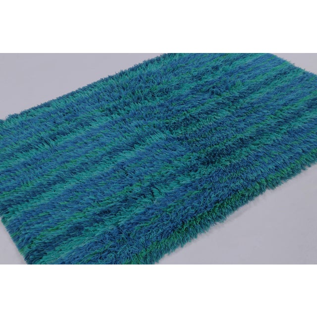 Hand-knotted in high-pile wool in Sweden circa 1960-1970, this 4x7 vintage Swedish Rya rug is a vibrant new addition to...