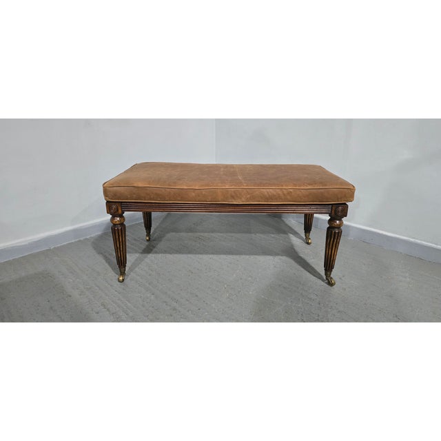 Very nice mahogany Regency-style stool, standing on reeded legs with brass cup castors, bergère top with a brown leather...