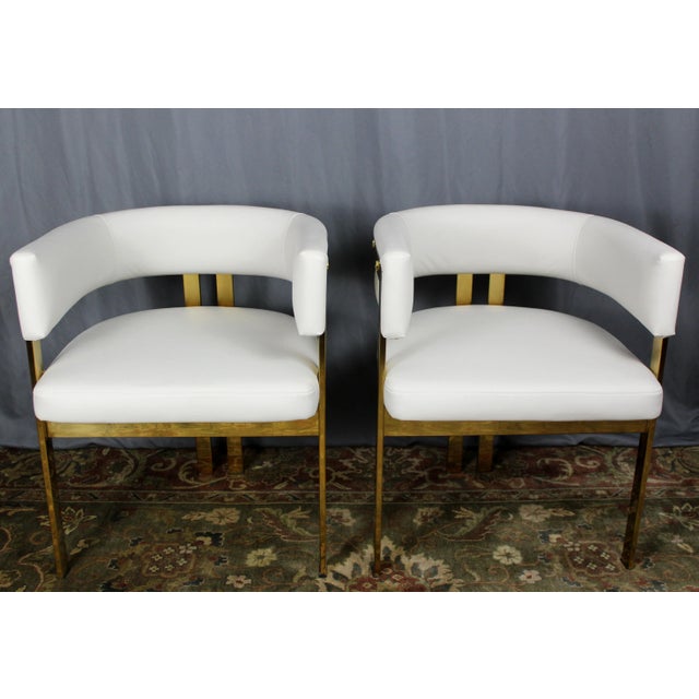 Pair of armchairs by Artistic Frame. Polished brass frames and leather upholstery on these Jamie model armchairs. These...