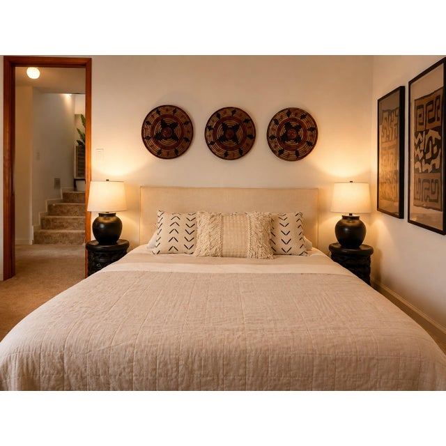 Off-white oblong fringe pillows have layers of tassels that lend a romantic feel. Styled on a bed in our Clear Lake Hearth...